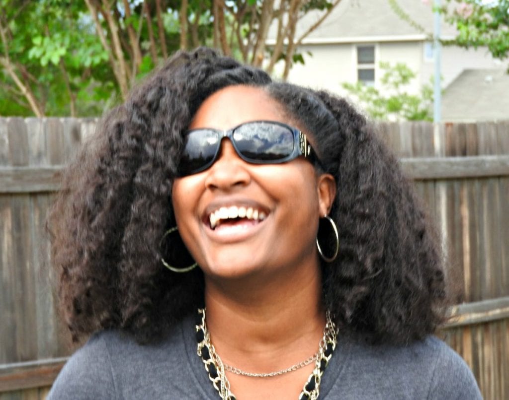 Jasmine Watts laughing with her sunglasses on