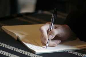 a person writing on a legal pad with a pen to study