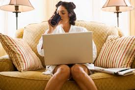 woman doing work on laptop and drinking coffee during holiday season