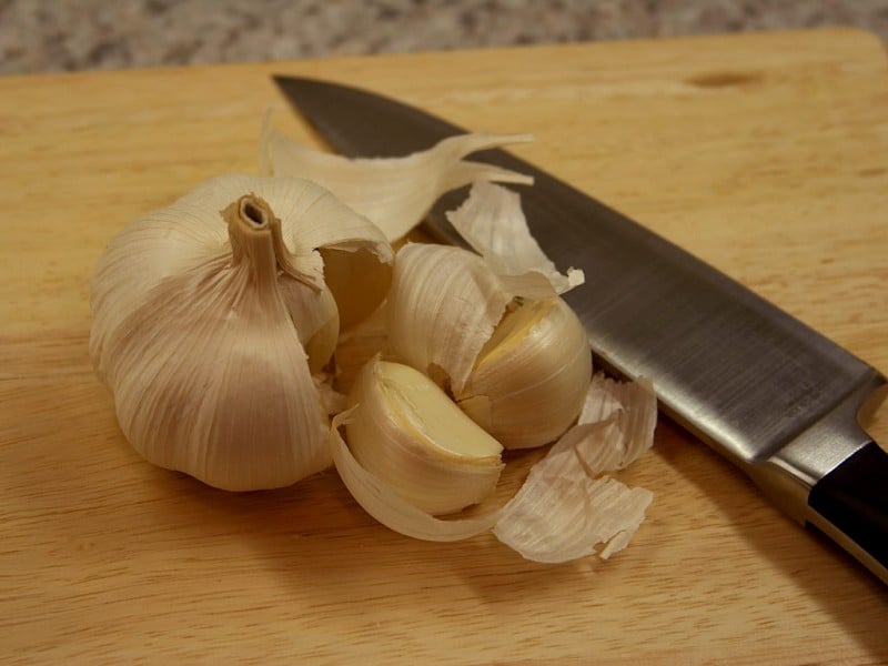 garlic on cutting board with knife