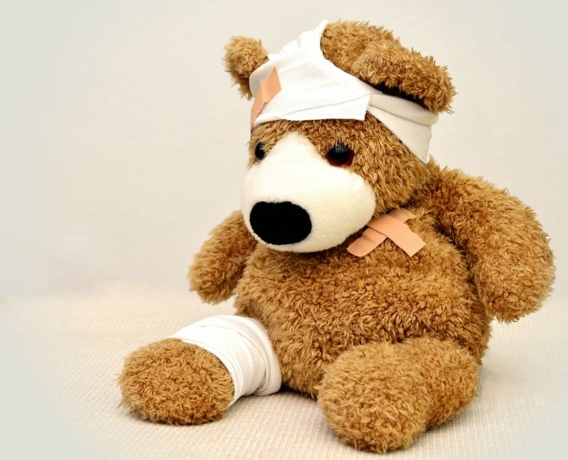 teddy bear wearing bandages from his trip to go to the doctor