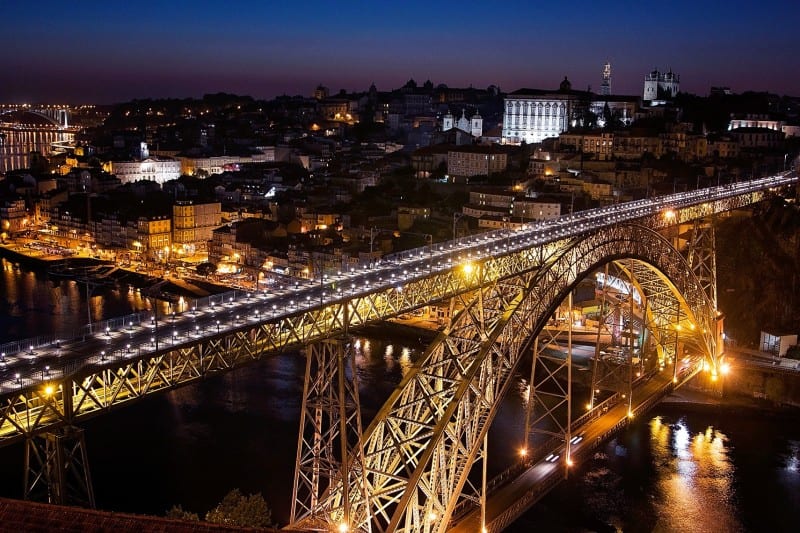 nighttime photo of bridge in Portugal showing why you should travel when you're young