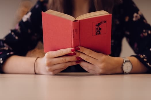 person reading book with red cover