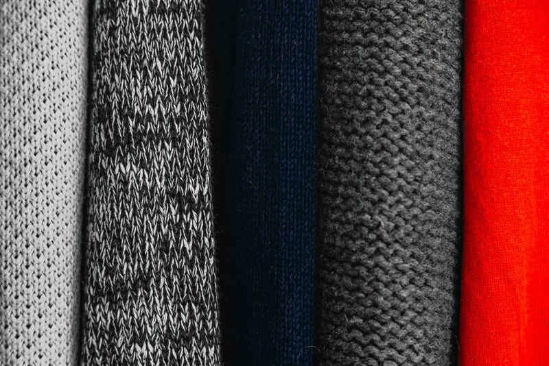 close-up of multi-colored sweaters for a capsule wardrobe