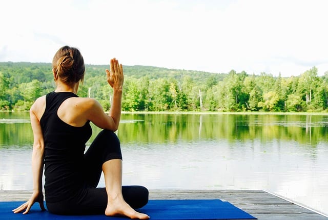 woman doing yoga by a lake