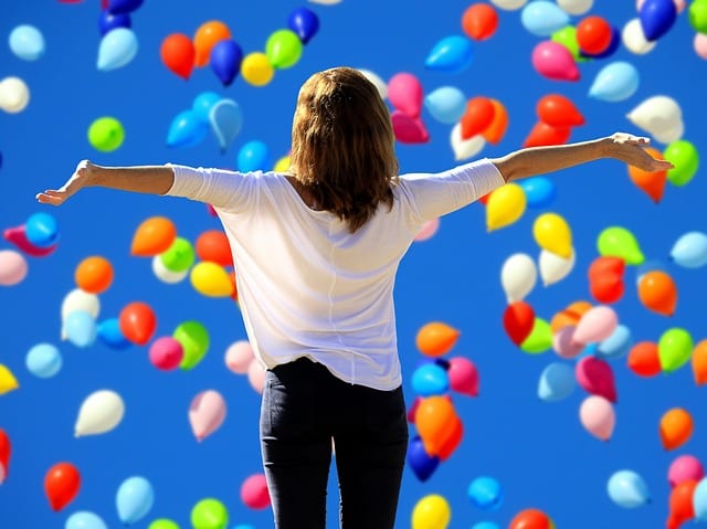 woman spreading her arms in front of ballons