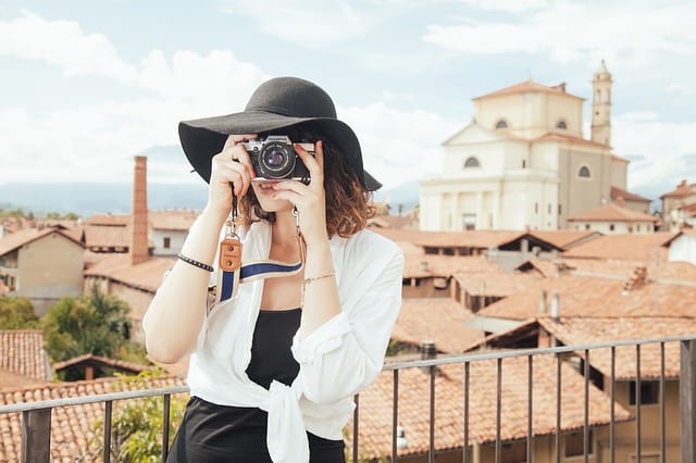 woman taking photo with city in background