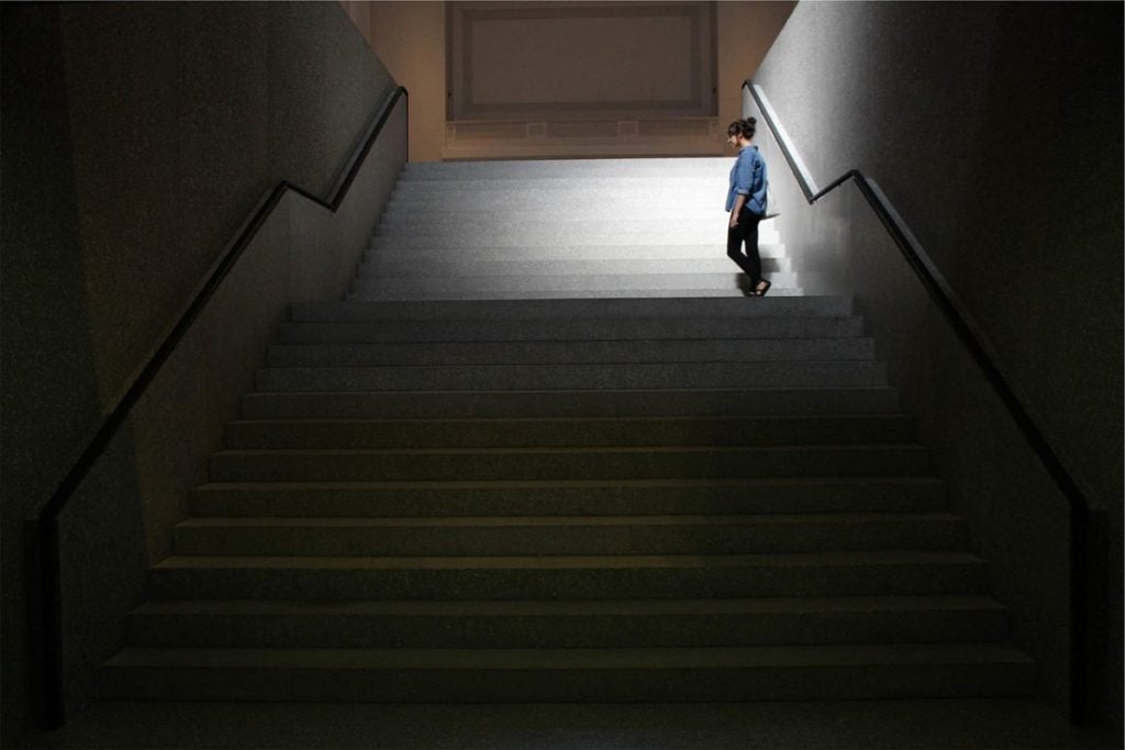 person standing on dark steps alone