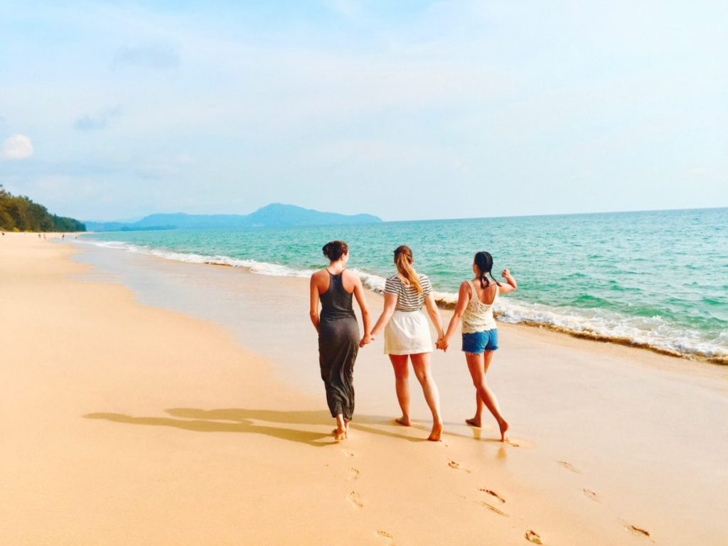 three women walking on beach