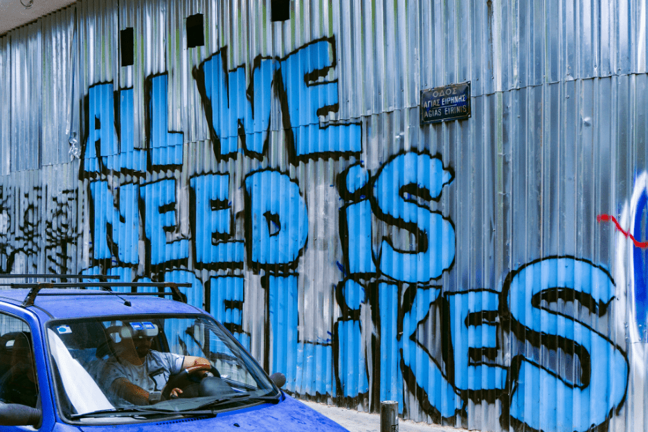 "All we need is likes" spray painted on an aluminum wall