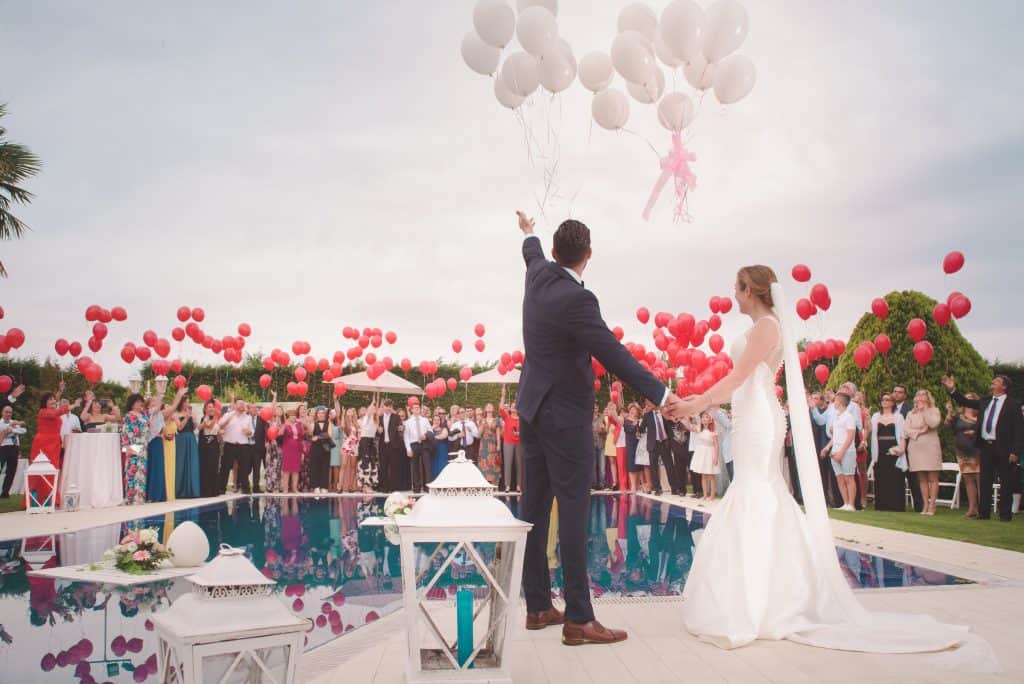 Wedding ceremony ending in a balloon release near a pool