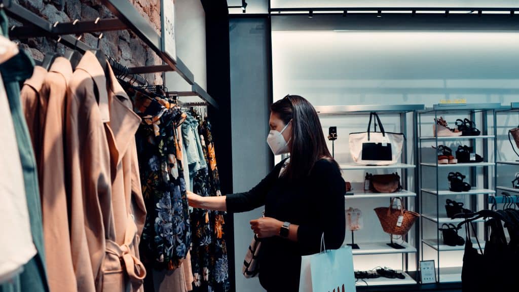 A woman shopping in a store while wearing a facemask 