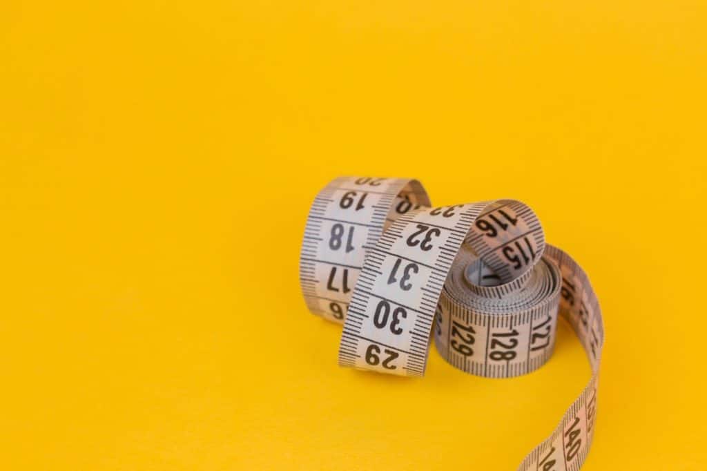 A measuring tape on a yellow background