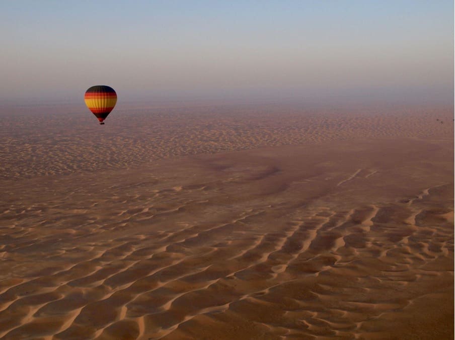 A hot air balloon flying over a desert