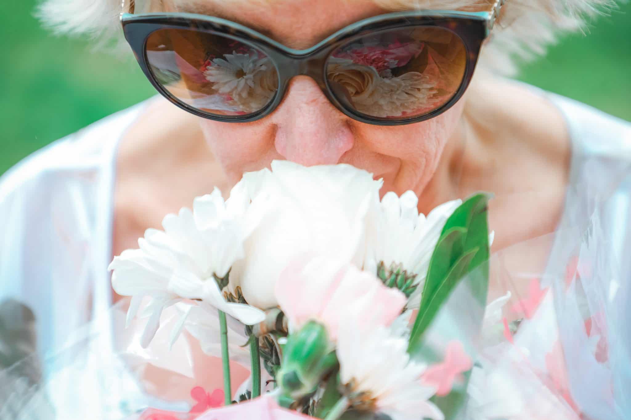 A grandmother sniffing flowers