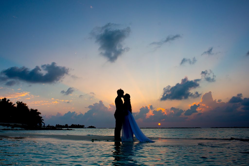 A couple at sunset taking wedding photos.