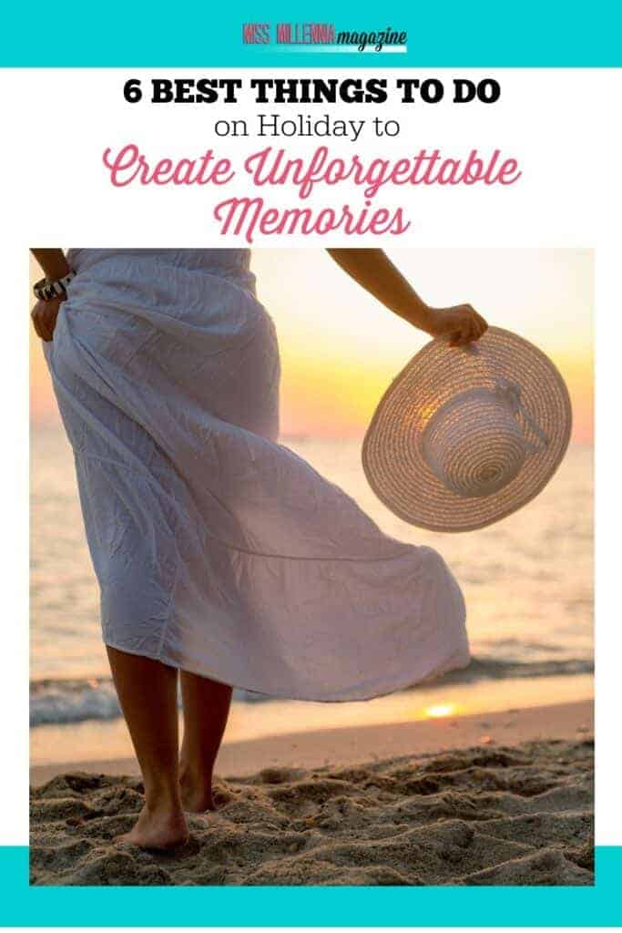 a woman in a white dress holding a hat on a beach